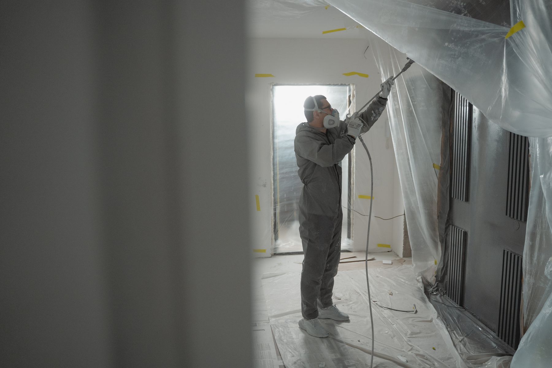 Worker in protective gear completing residential remediation work